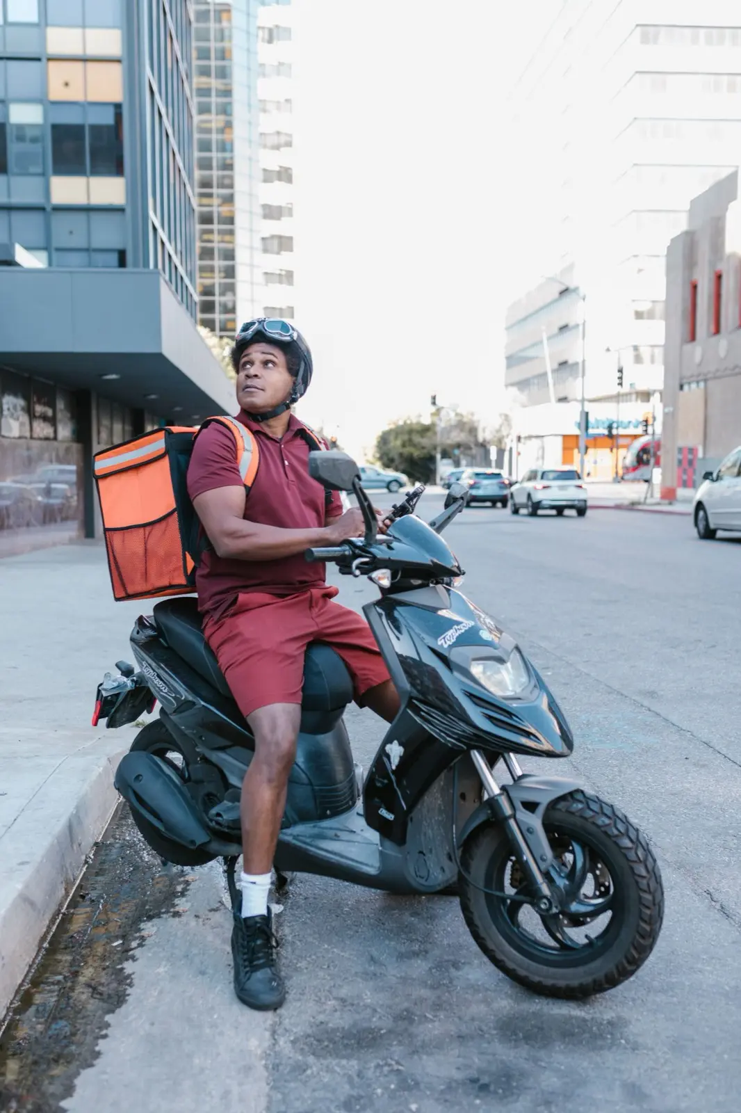 Delivery rider with an insulated food bag on his scooter